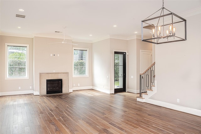 1530 Cunningham Parc Ln, Houston, TX 77055 - unfurnished living room featuring hardwood / wood-style floors, plenty of natural light, stairs, a glass covered fireplace, and ornamental molding