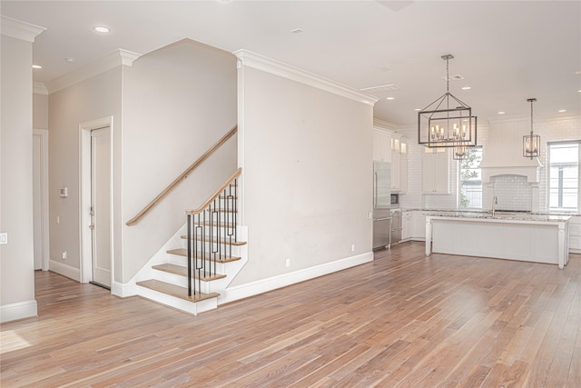 1530 Cunningham Parc Ln, Houston, TX 77055 - unfurnished living room featuring light wood-style flooring, a chandelier, recessed lighting, stairway, and crown molding