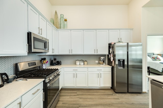 541 Green Meadows Dr, West Columbia, TX 77486 - kitchen with stainless steel appliances, light wood-style flooring, decorative backsplash, and white cabinetry