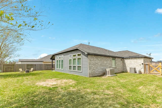 541 Green Meadows Dr, West Columbia, TX 77486 - rear view of house with a fenced backyard, a fire pit, and brick siding