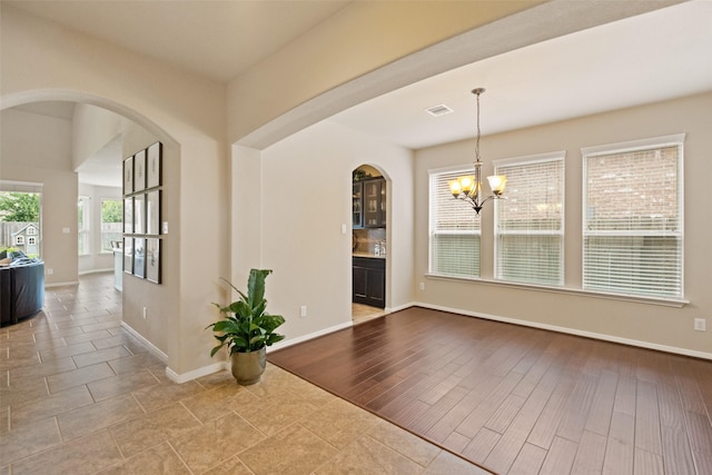 10002 Mahaffey Rd, Tomball, TX 77375 - unfurnished room with arched walkways and a chandelier