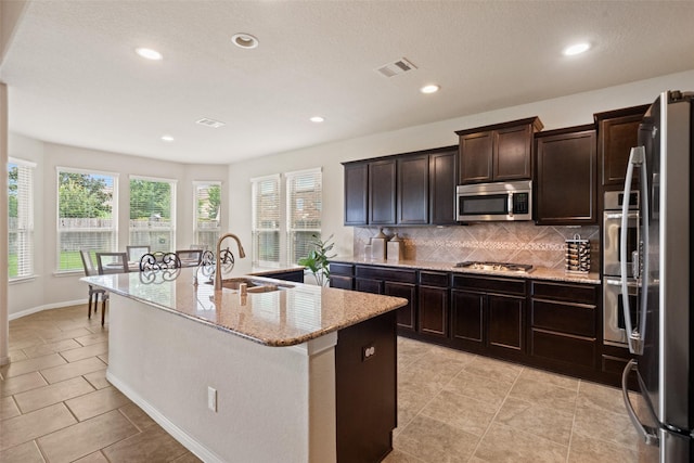 10002 Mahaffey Rd, Tomball, TX 77375 - kitchen featuring stainless steel appliances, tasteful backsplash, recessed lighting, light stone counters, and a kitchen island with sink