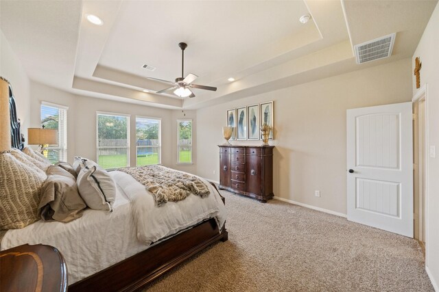 10002 Mahaffey Rd, Tomball, TX 77375 - bedroom featuring a tray ceiling, light carpet, ceiling fan, and recessed lighting