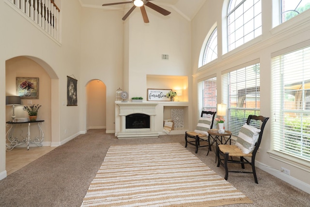17430 Autumn Oak Way, Spring, TX 77379 - carpeted living area featuring a ceiling fan, high vaulted ceiling, arched walkways, and a fireplace with raised hearth