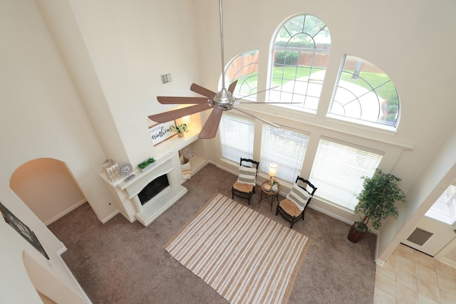 17430 Autumn Oak Way, Spring, TX 77379 - carpeted living area featuring a towering ceiling, a ceiling fan, and a fireplace with raised hearth