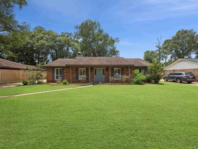 1135 Ivy Ln, Beaumont, TX 77706 - single story home with a front lawn and a chimney