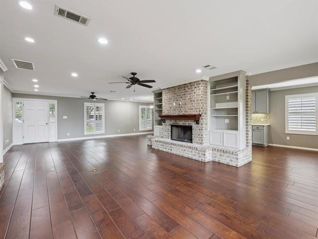1135 Ivy Ln, Beaumont, TX 77706 - unfurnished living room featuring a brick fireplace, ceiling fan, recessed lighting, dark wood finished floors, and crown molding