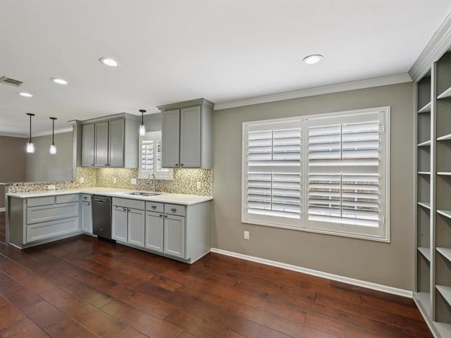 1135 Ivy Ln, Beaumont, TX 77706 - kitchen featuring dishwasher, gray cabinets, a peninsula, light countertops, and dark wood-type flooring