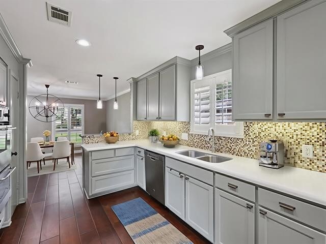 1135 Ivy Ln, Beaumont, TX 77706 - kitchen with stainless steel dishwasher, crown molding, a peninsula, gray cabinetry, and pendant lighting