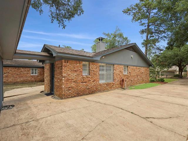 1135 Ivy Ln, Beaumont, TX 77706 - view of home's exterior featuring brick siding, a chimney, and a patio