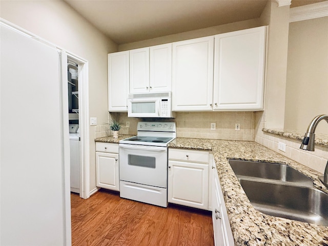 2400 Mccue Rd Unit 345, Houston, TX 77056 - kitchen with white appliances, light wood-type flooring, backsplash, white cabinets, and washer / dryer