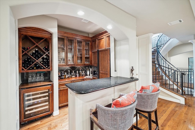 6506 Rodrigo St, Houston, TX 77007 - indoor dry bar featuring beverage cooler, light wood finished floors, stairs, and arched walkways