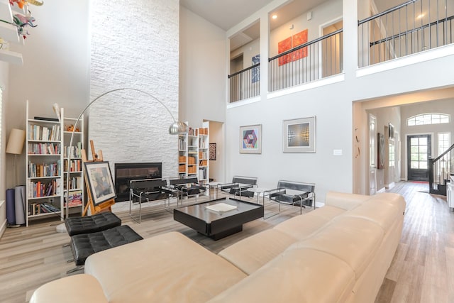 40 Snowdrop Lily Dr, Tomball, TX 77375 - living room featuring a high ceiling, a fireplace, and wood finished floors