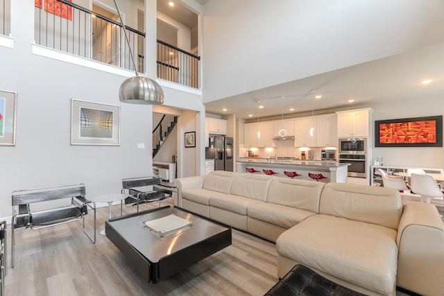 40 Snowdrop Lily Dr, Tomball, TX 77375 - living area featuring light wood finished floors, stairs, recessed lighting, and a towering ceiling
