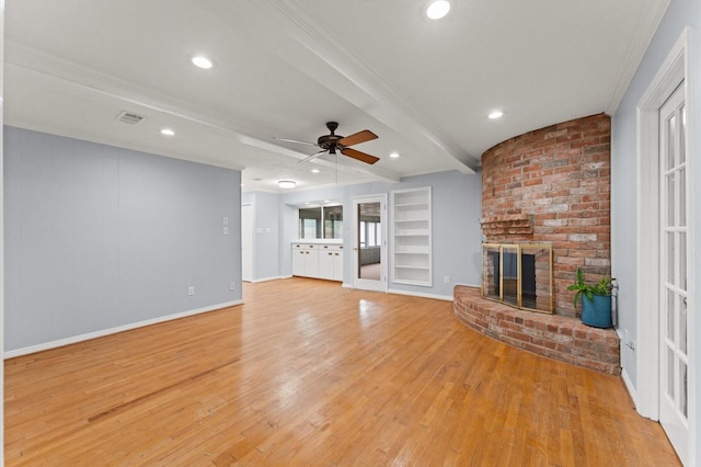 9310 Carvel Ln, Houston, TX 77036 - unfurnished living room with light wood-style flooring, a brick fireplace, ceiling fan, beamed ceiling, and crown molding