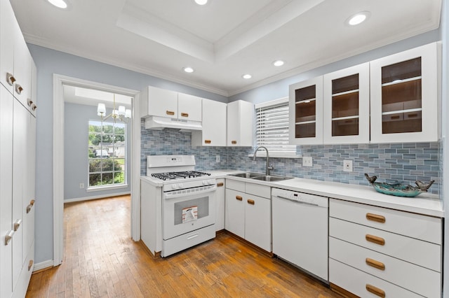 9310 Carvel Ln, Houston, TX 77036 - kitchen featuring white appliances, under cabinet range hood, light countertops, ornamental molding, and backsplash