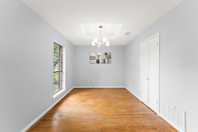 9310 Carvel Ln, Houston, TX 77036 - unfurnished room with a chandelier, light wood-style floors, and a raised ceiling