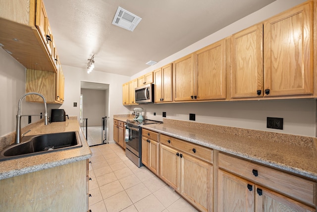 741 Rutgers Ln, Deer Park, TX 77536 - kitchen featuring stainless steel appliances, light tile patterned floors, and light brown cabinetry