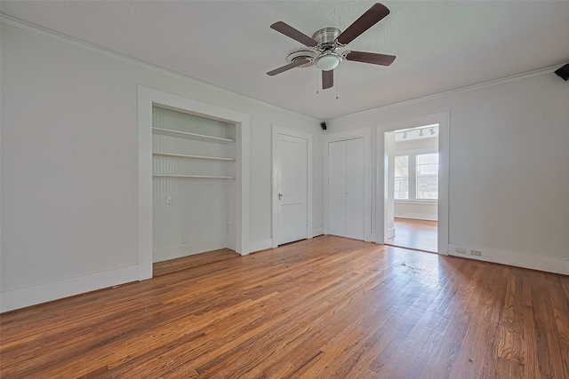 227 Lakeview Dr, Sugar Land, TX 77498 - unfurnished bedroom featuring crown molding, wood finished floors, two closets, and a ceiling fan