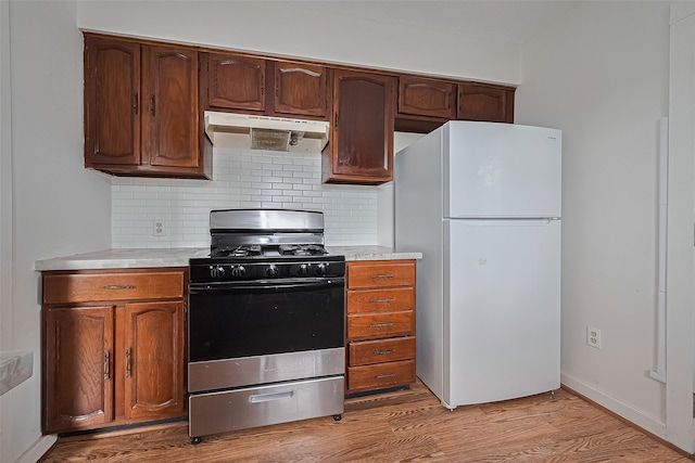 227 Lakeview Dr, Sugar Land, TX 77498 - kitchen with freestanding refrigerator, stainless steel gas range, under cabinet range hood, and light countertops