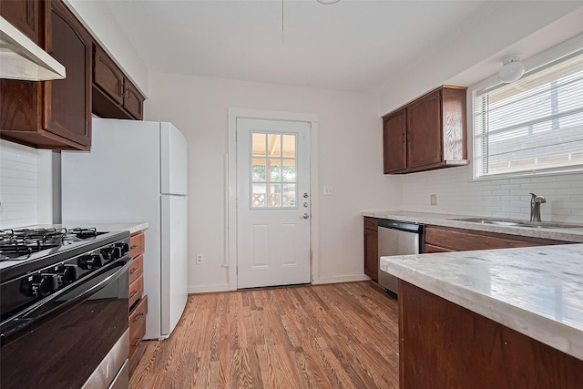 227 Lakeview Dr, Sugar Land, TX 77498 - kitchen featuring under cabinet range hood, black gas range, stainless steel dishwasher, light countertops, and backsplash