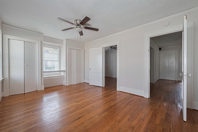 227 Lakeview Dr, Sugar Land, TX 77498 - unfurnished bedroom with wood finished floors, ornamental molding, two closets, a textured ceiling, and a ceiling fan