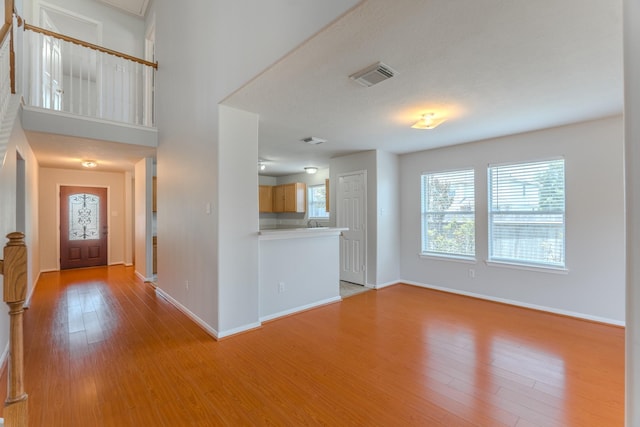 17203 Morning Blossom Pl, Houston, TX 77084 - unfurnished living room with baseboards and light wood-type flooring