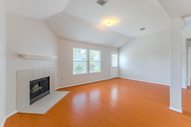 17203 Morning Blossom Pl, Houston, TX 77084 - unfurnished living room with vaulted ceiling, a fireplace, and light wood-style flooring