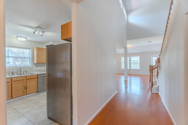 17203 Morning Blossom Pl, Houston, TX 77084 - hall featuring stairway, plenty of natural light, light wood finished floors, and a textured ceiling