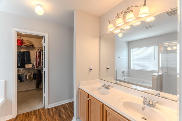 17203 Morning Blossom Pl, Houston, TX 77084 - full bath featuring wood finished floors, a bath, a spacious closet, a stall shower, and double vanity