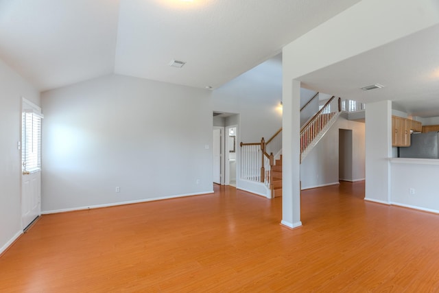 17203 Morning Blossom Pl, Houston, TX 77084 - unfurnished living room featuring light wood-style flooring, stairs, and lofted ceiling