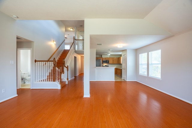 17203 Morning Blossom Pl, Houston, TX 77084 - unfurnished living room featuring light wood-style flooring and stairs