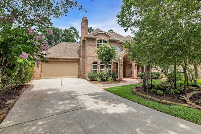 130 Amulet Oaks Ct, The Woodlands, TX 77382 - view of front of home featuring brick siding, driveway, a garage, and a shingled roof