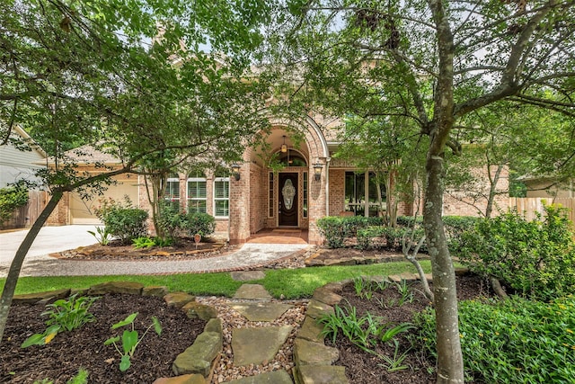 130 Amulet Oaks Ct, The Woodlands, TX 77382 - obstructed view of property with brick siding, concrete driveway, and a garage