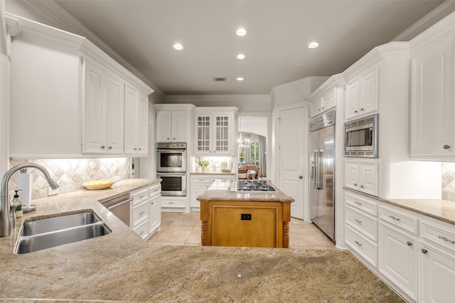 130 Amulet Oaks Ct, The Woodlands, TX 77382 - kitchen with built in appliances, light tile patterned flooring, white cabinetry, recessed lighting, and crown molding