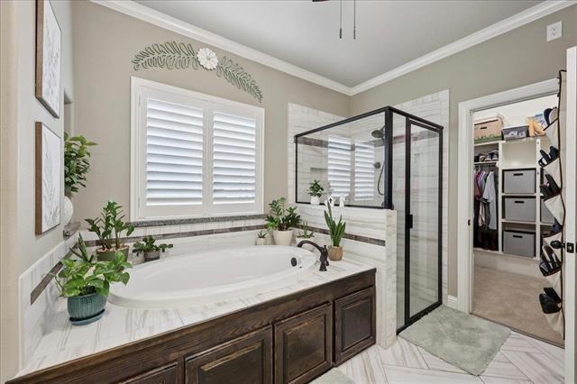 271 Hannah Ln, Lumberton, TX 77657 - bathroom featuring a garden tub, a shower stall, a walk in closet, and crown molding