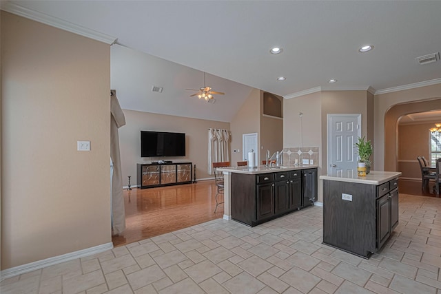 3415 Monarch Meadow Ln, Pearland, TX 77581 - kitchen with arched walkways, light countertops, a center island, open floor plan, and a ceiling fan