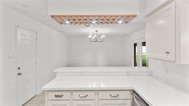 5010 Redstart St, Houston, TX 77035 - kitchen featuring a peninsula, a chandelier, white cabinets, light stone countertops, and dishwasher