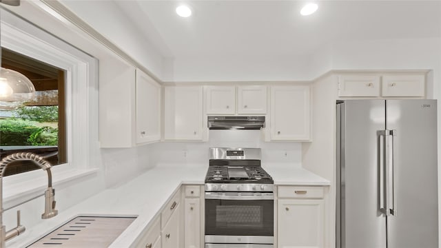 5010 Redstart St, Houston, TX 77035 - kitchen with stainless steel appliances, under cabinet range hood, white cabinetry, light countertops, and recessed lighting