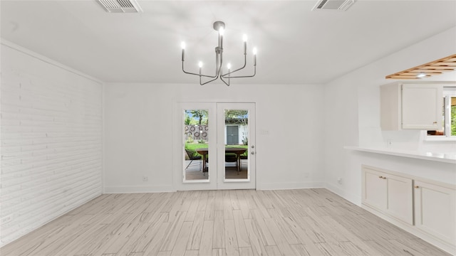 5010 Redstart St, Houston, TX 77035 - unfurnished dining area featuring plenty of natural light, a chandelier, light wood finished floors, french doors, and brick wall
