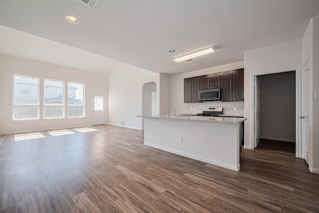10314 White Fir Villa Ave, Houston, TX 77044 - kitchen featuring stainless steel microwave, arched walkways, dark wood-style floors, dark brown cabinets, and stove