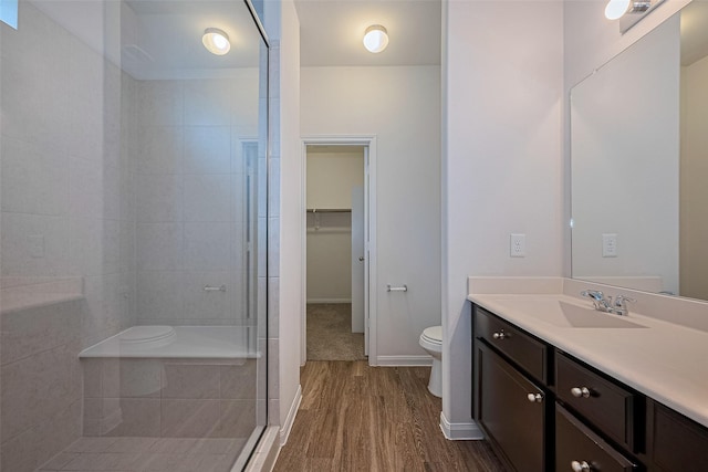 10314 White Fir Villa Ave, Houston, TX 77044 - full bathroom with a stall shower, wood finished floors, vanity, and a walk in closet