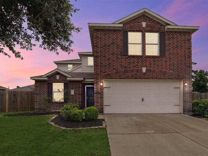 10208 Red Fern Ct, Conroe, TX 77385 - traditional home featuring brick siding, a garage, and driveway