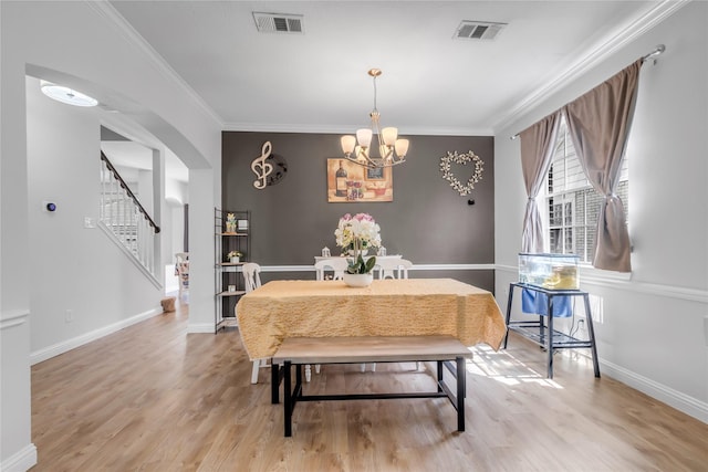 5506 Poundstone Ct, Sugar Land, TX 77479 - dining space with light wood-style floors, a chandelier, crown molding, stairway, and arched walkways