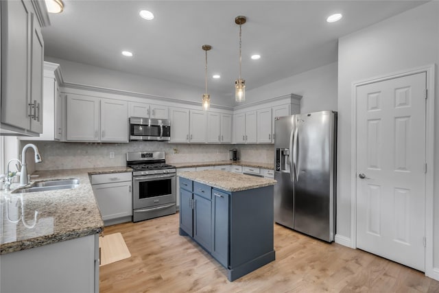 5506 Poundstone Ct, Sugar Land, TX 77479 - kitchen featuring appliances with stainless steel finishes, a kitchen island, tasteful backsplash, light stone counters, and hanging light fixtures