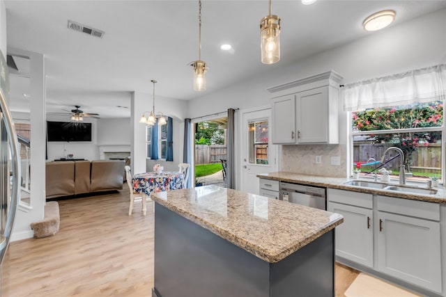 5506 Poundstone Ct, Sugar Land, TX 77479 - kitchen with dishwasher, a kitchen island, ceiling fan, backsplash, and light stone counters