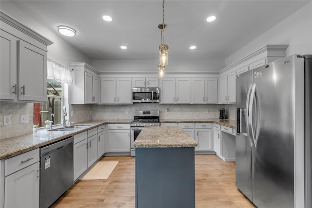 5506 Poundstone Ct, Sugar Land, TX 77479 - kitchen with appliances with stainless steel finishes, a kitchen island, decorative backsplash, pendant lighting, and light stone countertops