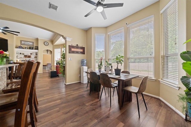 210 Southwood Cir, Baytown, TX 77520 - dining space with ceiling fan, arched walkways, dark wood-type flooring, and healthy amount of natural light
