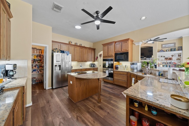 210 Southwood Cir, Baytown, TX 77520 - kitchen with a ceiling fan, appliances with stainless steel finishes, light stone counters, dark wood-style floors, and tasteful backsplash