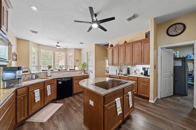 210 Southwood Cir, Baytown, TX 77520 - kitchen with black appliances, a ceiling fan, a kitchen island, dark wood-type flooring, and recessed lighting